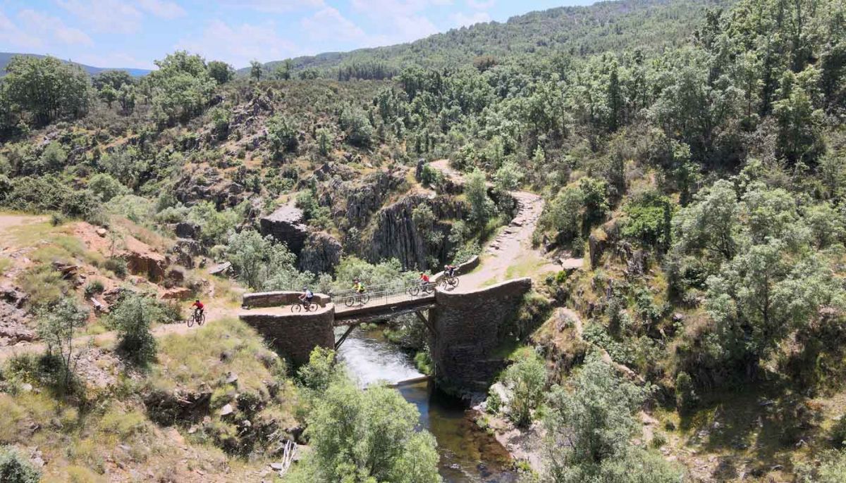 Ciclistas atraviesan el puente de los trillos entre roblelacasa y matallana cerca de las cascadas del aljibe